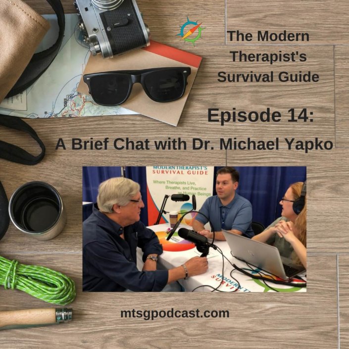 Photo ID: a wooden tabletop with a map, sunglasses, a camera, a thermos, some paracord, and a leather and canvas bag with a picture of Curt and Katie chatting with Dr. Yapko at The Evolution of Psychotherapy Conference with text overlay "Episode 14: A Brief Chat with Dr. Michael Yapko"